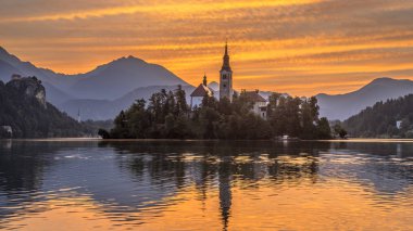 Kilise turuncu sabah gökyüzü altında ile Lake bled