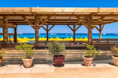 Korsika Bulvarı, Fransa 'da gölgeli koşullar için yeşil bitkileri olan bir sahil restoranı..