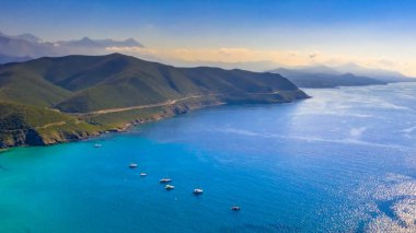 Mavi Akdeniz 'deki Korsika kıyı şeridinin yelkenli tekneli havadan görüntüsü