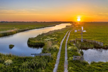 Hollanda, Noord Hollanda, Jisp yakınlarındaki Hollanda 'da günbatımında Amerikan yel değirmeninin hava manzarası