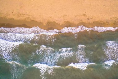 Korsika, Fransa 'nın altın renkli plajındaki deniz dalgalarının yukarıdan görünüşü.