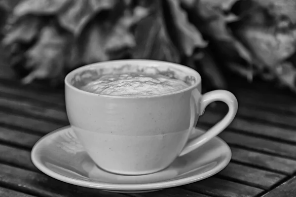 Xícara de café com cappuccino no fundo de madeira velha — Fotografia de Stock