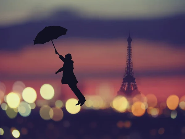 Arka plan: gece Paris, Fransa, Eyfel Kulesi ile üzerinde uçan şemsiye tutan bir adam silüeti — Stok fotoğraf