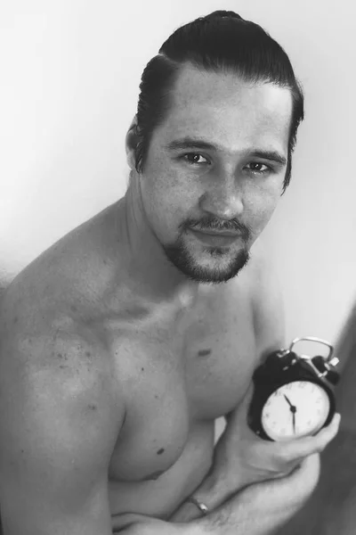 Красивий, мускулистий молодий чоловік тримає годинник — стокове фото