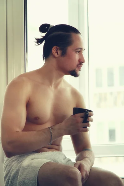 Bonito, jovem musculoso em toalha branca com xícara de café — Fotografia de Stock