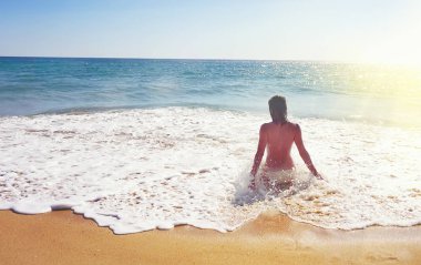 Albufeira, Portekiz, güzel plajda sörf oturan üstsüz kadın