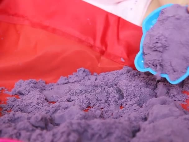 Тоддлер играет с Пурпурным кинетическим песком крупным планом — стоковое видео