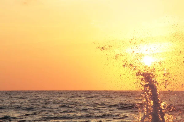 Splash van zee Golf bij zonsondergang. Tegen licht. Reis- en — Stockfoto