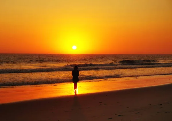 Silueta de la mujer hermosa en la puesta del sol del mar —  Fotos de Stock