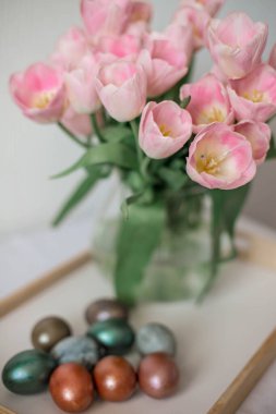 Beyaz tabakta güzel renkli, parlak paskalya yumurtaları. Pembe tul