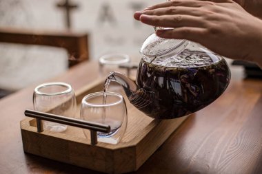 Mor bitkisel çay biracıdan fincana dökülür..