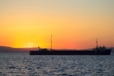 Arka planda günbatımı kargo ile denizde gemiler