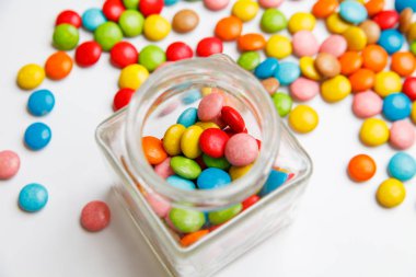 Cam Kavanoz renkli şeker ile kurullarında dağınık. tasarımınız için Festival arka plan.