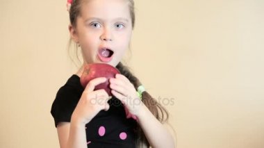 Küçük kız elma yiyor.
