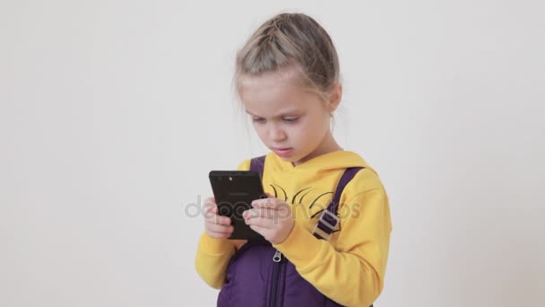 Kleines Mädchen spielt und berührt ein Mobiltelefon — Stockvideo