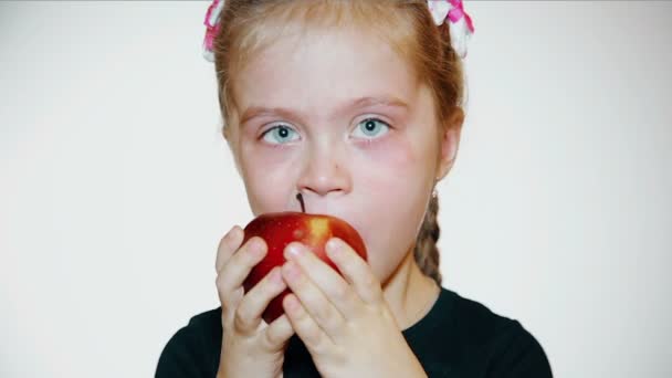 Verdrietig meisje eet een appel — Stockvideo