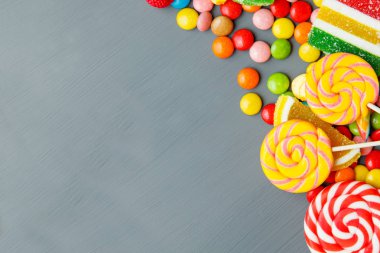Gri ahşap masa üzerinde karışık renkli şekerler