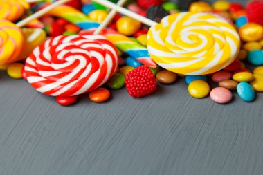 Gri ahşap masa üzerinde karışık renkli şekerler