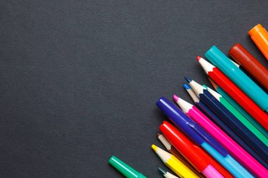 Koyu arka plan üzerinde renkli kalemler