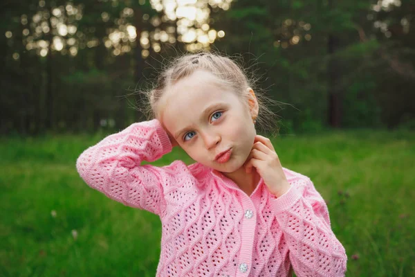 Gyönyörű barna kék szeme kicsi lány portré a park zöld fűben — Stock Fotó