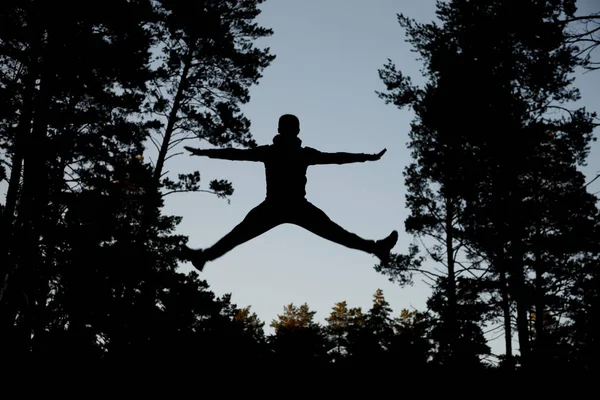 Silhouette jumping man against blue sky. — Stock Photo, Image