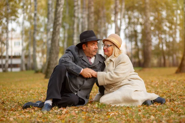 Elderly couple in the autumn park — Stock Photo, Image