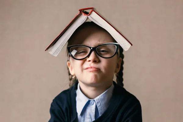 Petite fille avec un livre sur la tête — Photo