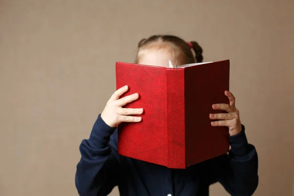 Beau bébé couvrant son visage avec un livre . — Photo