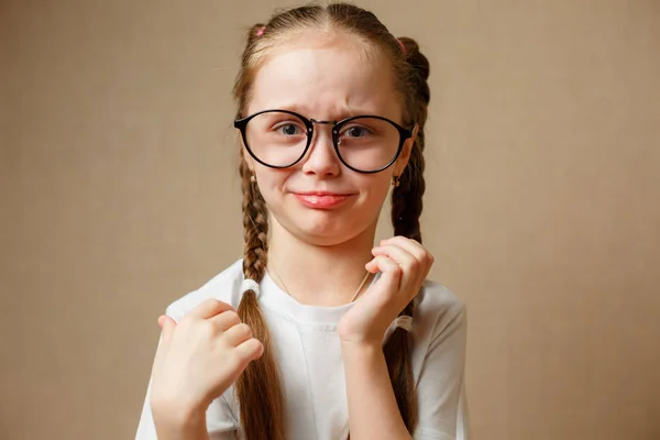 Petite fille avec des lunettes dans un t-shirt blanc Photo De Stock