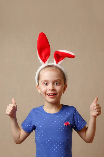 Retrato de una linda niña vestida con orejas de conejo de Pascua muestra el gesto perfectamente —  Fotos de Stock