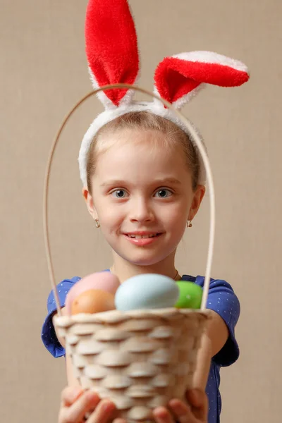 Niña con orejas de conejo sosteniendo una cesta con huevos de Pascua —  Fotos de Stock