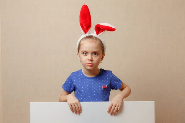 Hermosa niña con orejas de conejo y pancarta en blanco. Feliz Pascua. —  Fotos de Stock