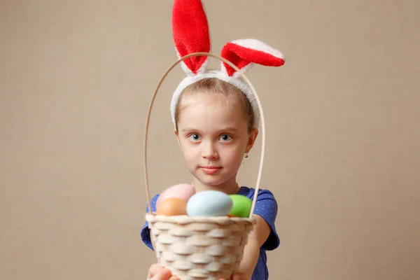 Adorable niña pequeña con orejas de conejo jugando con huevos de Pascua —  Fotos de Stock