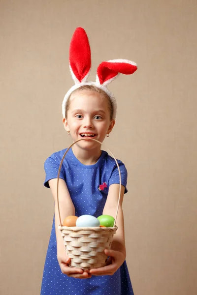 Lindo niño pequeño con orejas de conejo en el día de Pascua. Cesta de niña con huevos pintados. —  Fotos de Stock