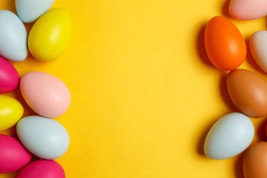 Sarı arka planda renkli paskalya yumurtaları