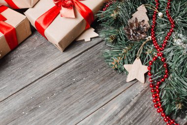 Noel arkaplanı. Ladin dalları, köknar kozalakları ve gri arka planda şenlik dekoru. Mesaj için yer. Tebrik kartı.