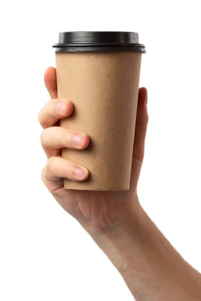 Tema colazione e caffè: mano dell'uomo che tiene vuota tazza di caffè di carta con un tappo di plastica marrone isolato su uno sfondo bianco in studio, caffè pubblicitario — Foto Stock