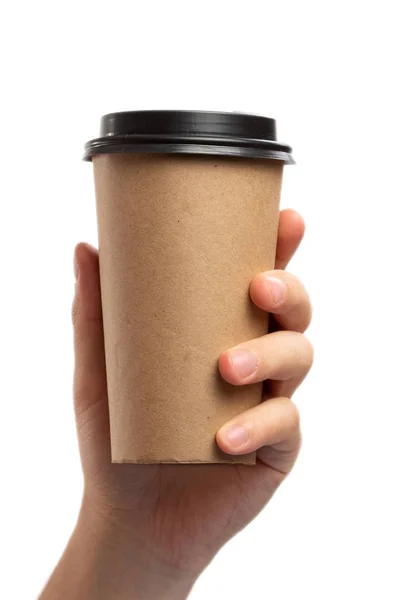 Tema colazione e caffè: mano dell'uomo che tiene vuota tazza di caffè di carta con un tappo di plastica marrone isolato su uno sfondo bianco in studio, caffè pubblicitario — Foto Stock