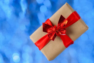 Mavi bir bokeh üzerinde uçan hediye kutusu. Tatil konsepti, Noel. Yükselme