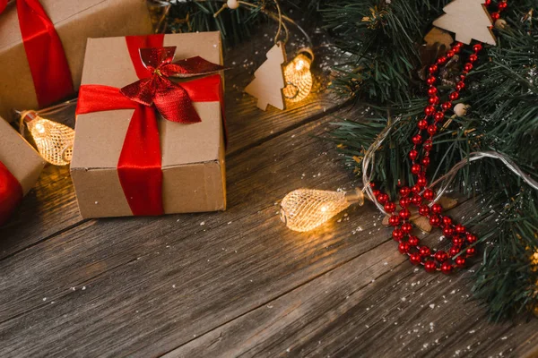 Tahta yüzeyde ışıkları olan Xmas hediye kutuları