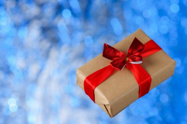 Mavi bir bokeh üzerinde uçan hediye kutusu. Tatil konsepti, Noel. Yükselme