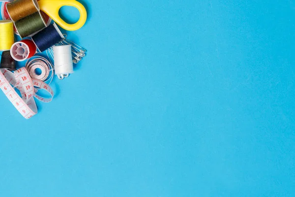 青色の背景にスレッドスプールのテーラーメイド機器 — ストック写真