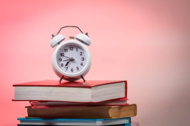 Çalar saat yığını kitap masası. Eğitim kavramı.