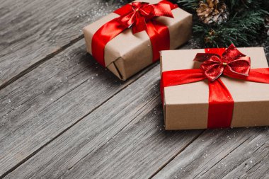 Noel hediyesi kutusu, yemek dekoru ve ağaç dalları ahşap masada. Kopyalama alanı olan üst görünüm