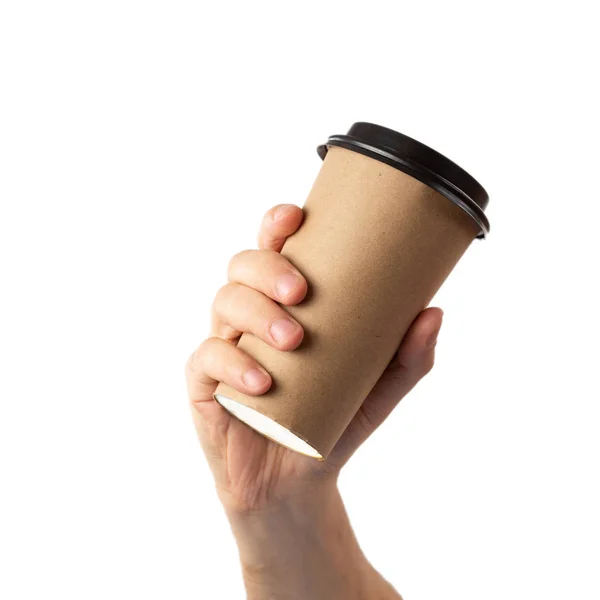 Uomo mano tenendo marrone tazza di carta di caffè con coperchio nero isolato su sfondo bianco . — Foto Stock