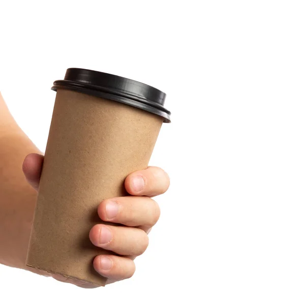 Uomo mano tenendo marrone tazza di carta di caffè con coperchio nero isolato su sfondo bianco . — Foto Stock