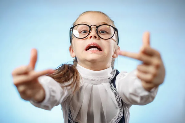 Iskolás lány szemüvegben középujjat mutat. Sértő gesztus. Egy kölyök. — Stock Fotó