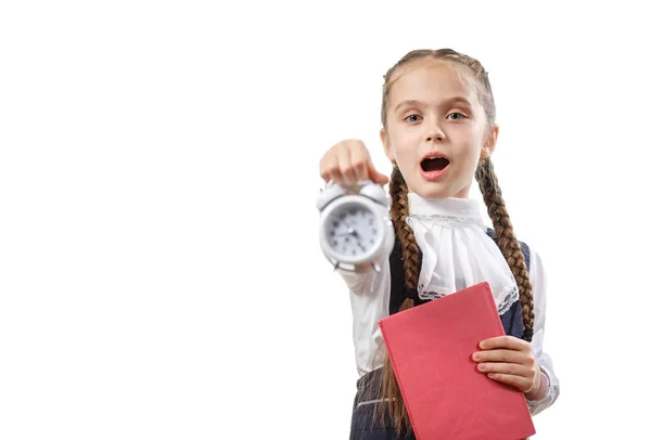 Csinos kis kaukázusi lány fehér blúzban tartsa riasztó óra, mutatja óra — Stock Fotó