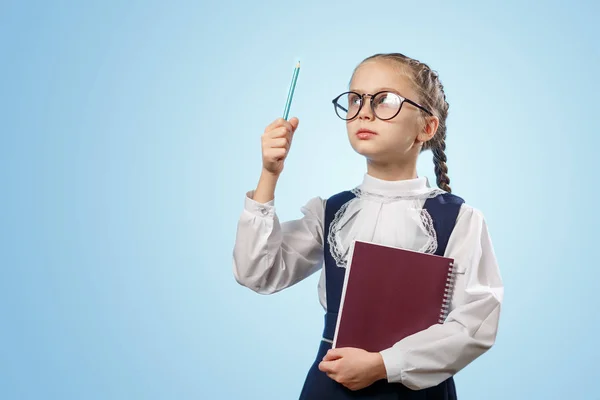 Grappig meisje met een bril kwam met een geweldig idee. Model tiener op blauwe achtergrond — Stockfoto