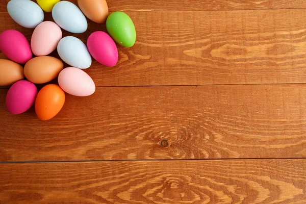 Ahşap masa arka plan üzerinde renkli Paskalya yumurtaları — Stok fotoğraf